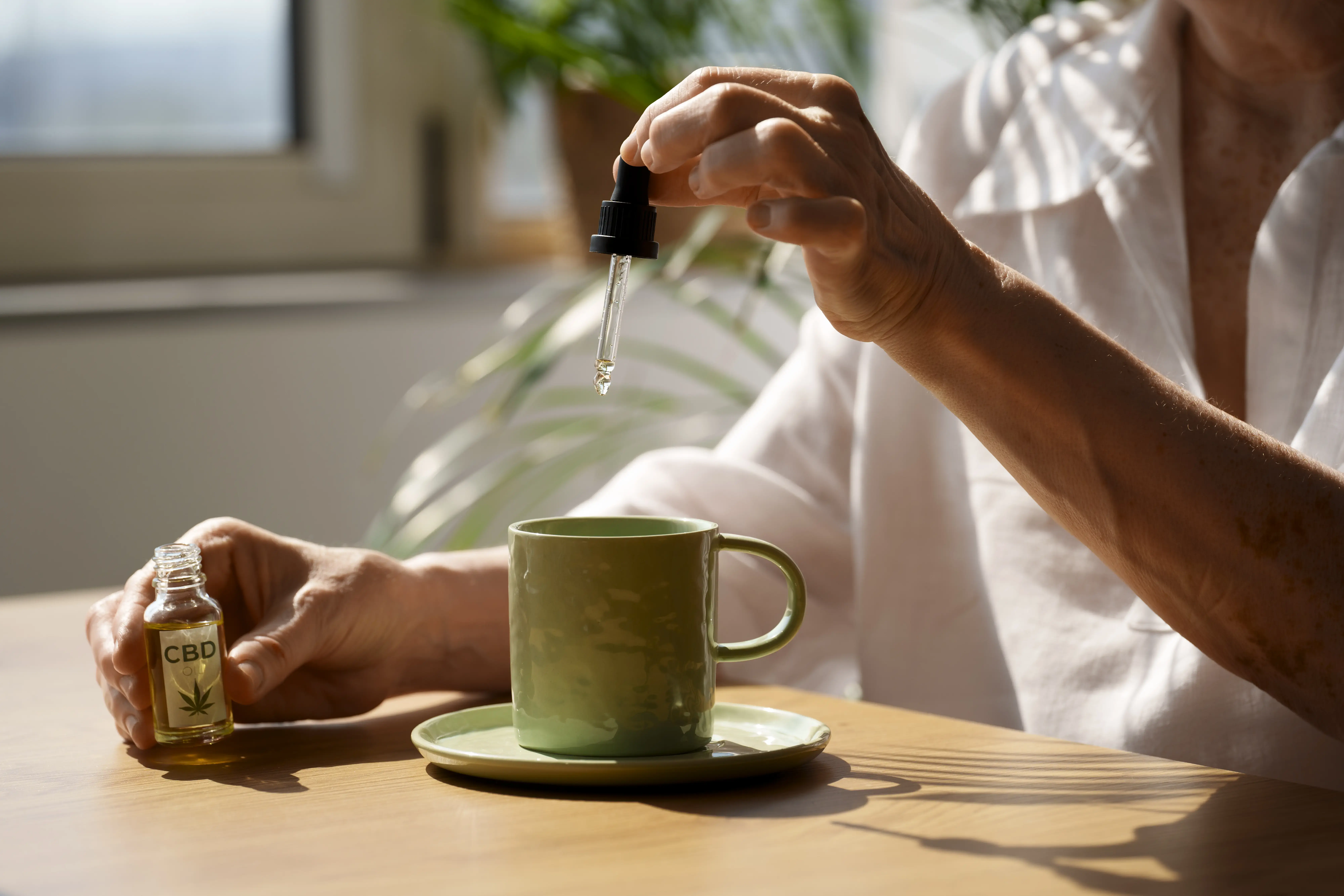 Lahvička vonného oleje obklopená sušenými bylinkami