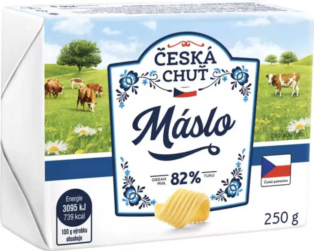 Máslo na dřevěném prkénku s nožem vedle