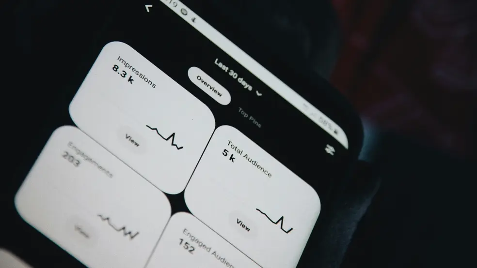 Blízký záběr na mobilní telefon zobrazující statistiky a grafy výkonu