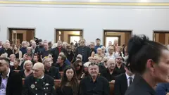 Hosté a veřejnost vzdávají hold Jiřímu Krampolovi u obřadní síně