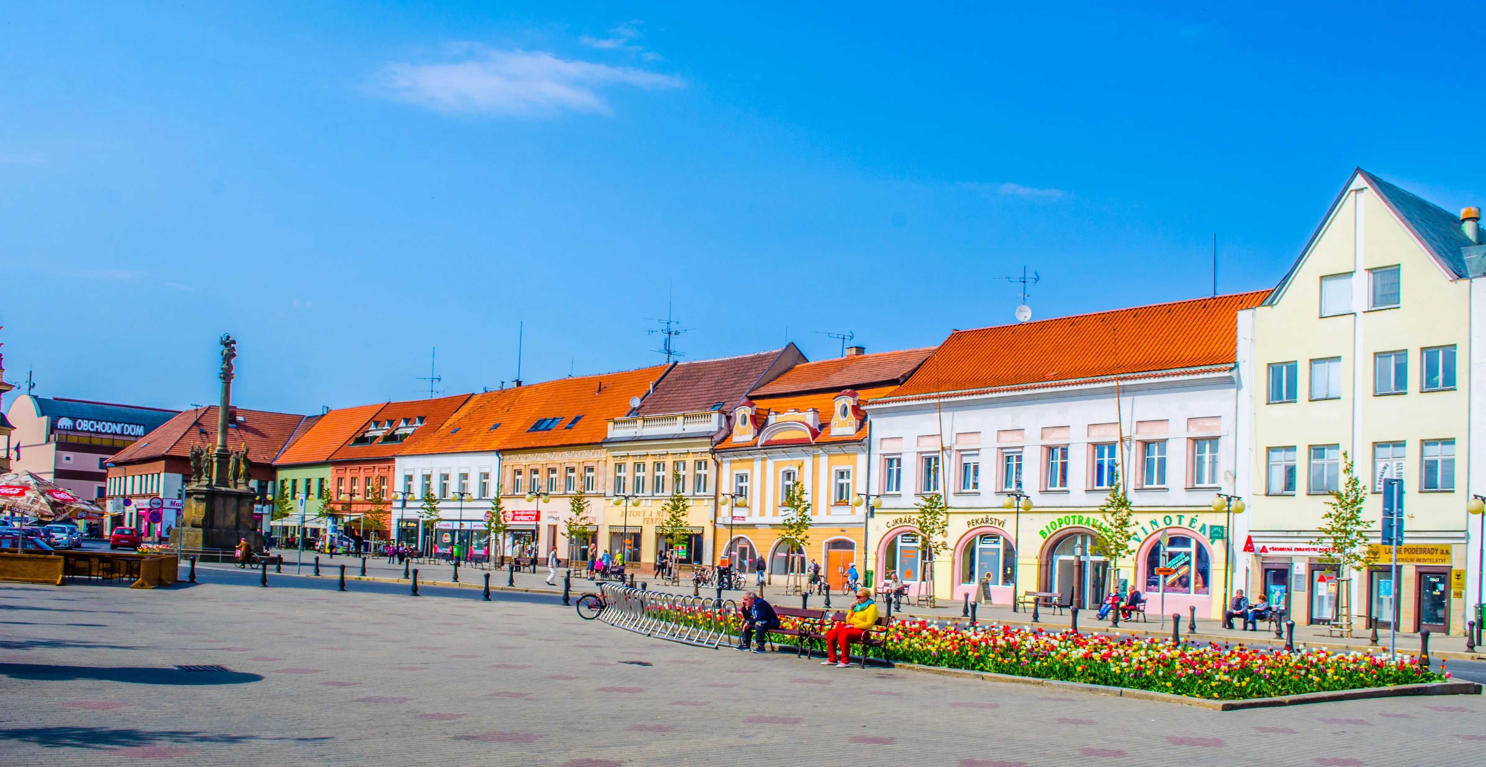 Centrum českého města s barevnými domy a lidmi na ulici,