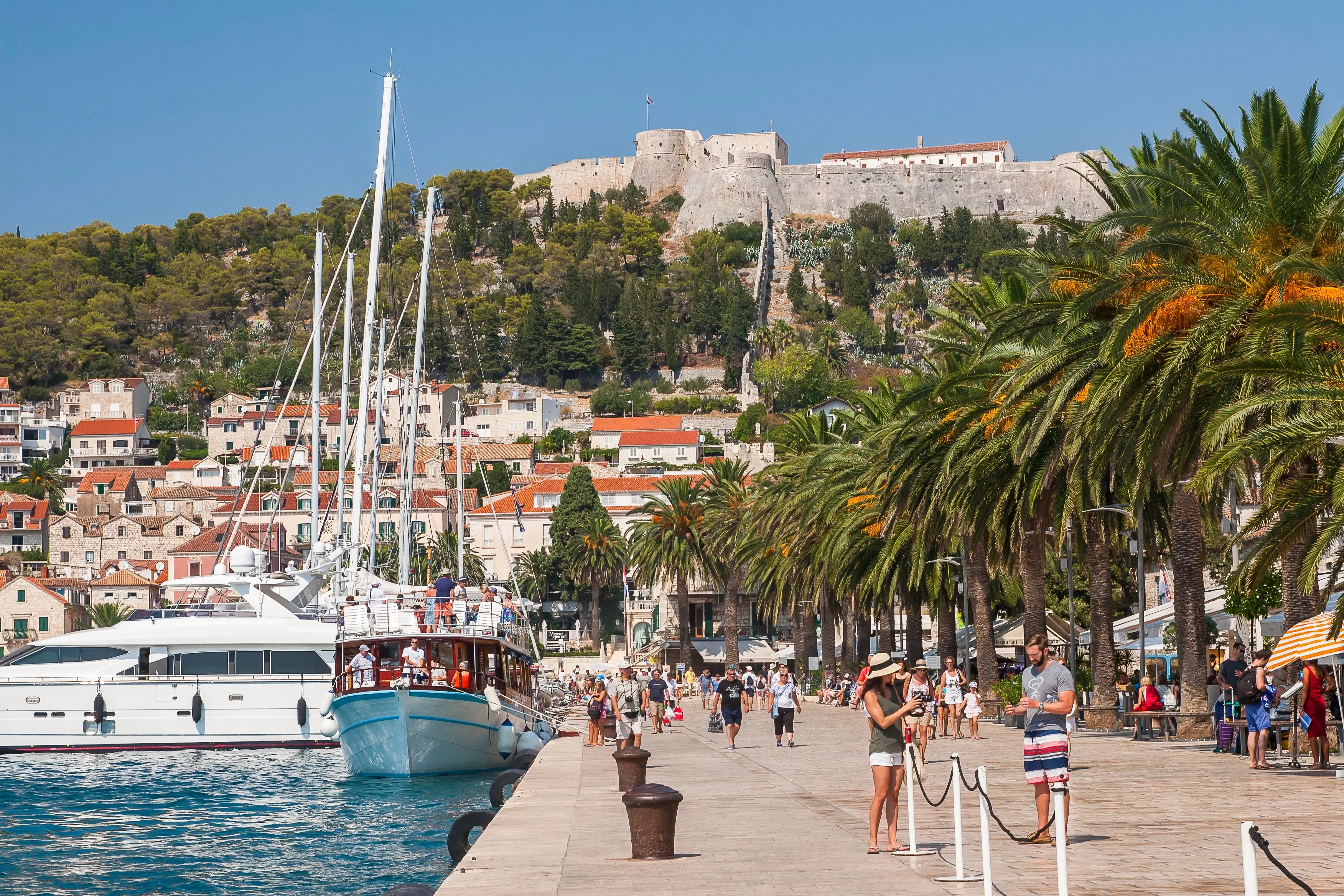 Malebný přístav na chorvatském ostrově Vis s loďkami a kamennými domy