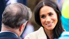 Detailní záběr na Meghan Markle, jak se usmívá při rozhovoru