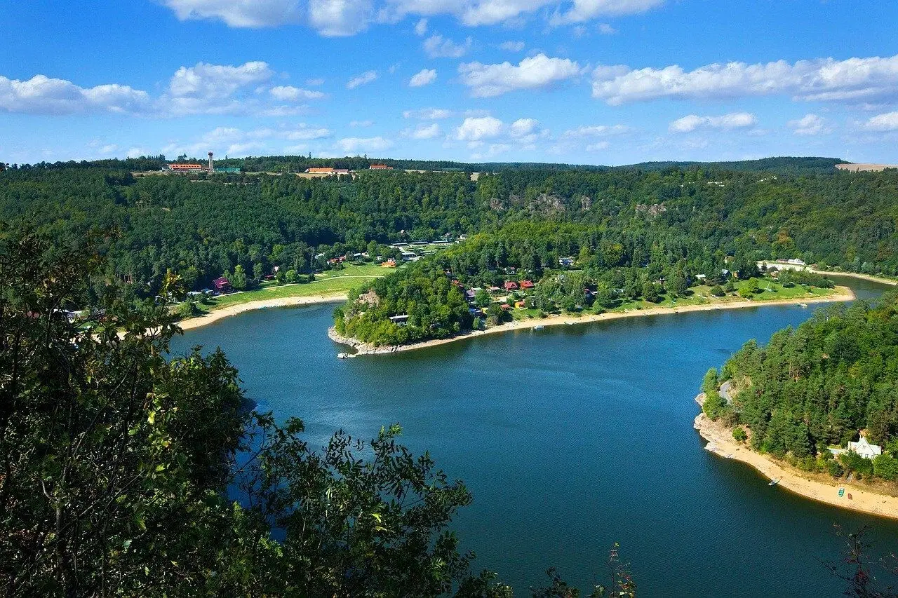Modrá hladina Jadranu obklopená zelení.