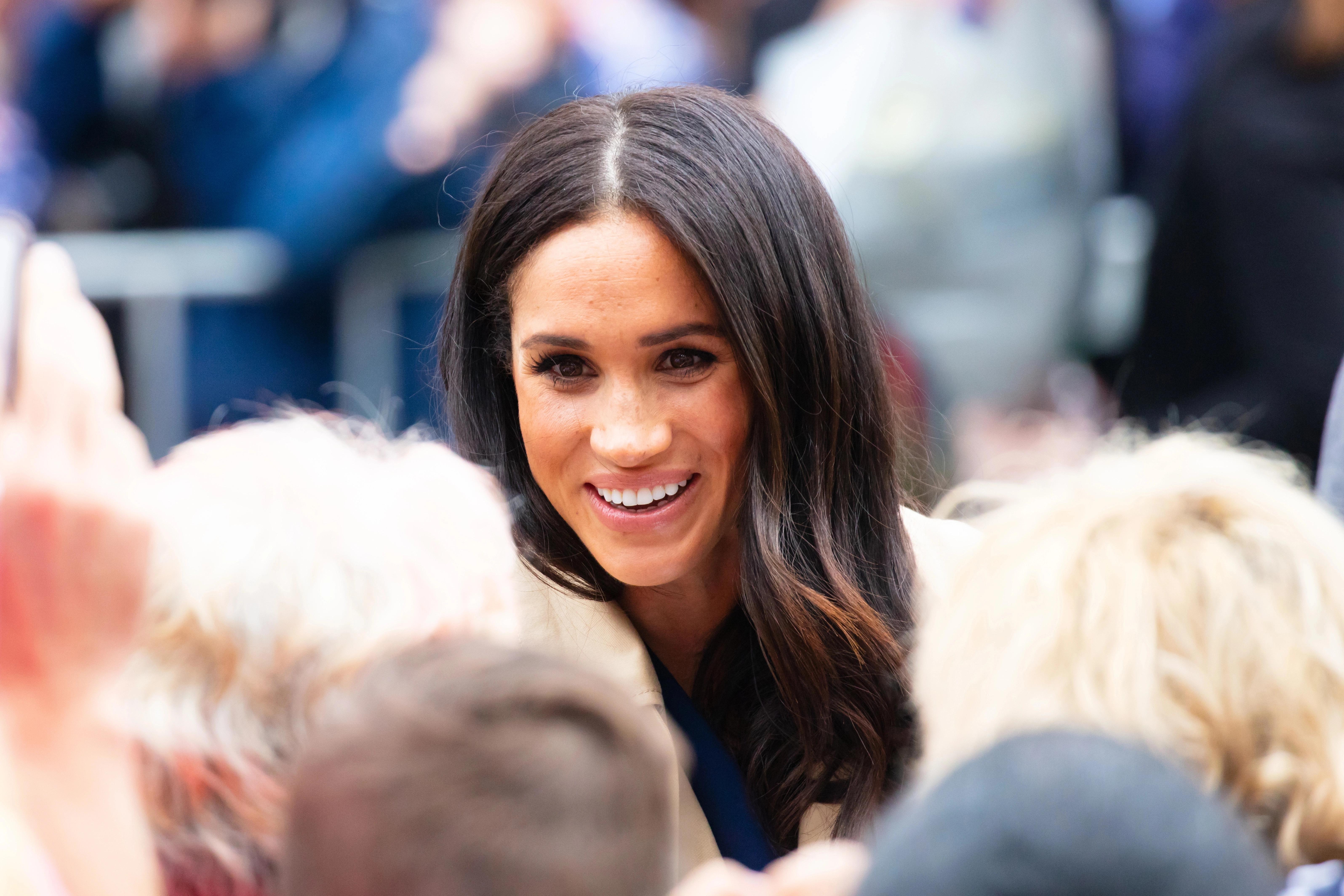 Meghan Markle se usmívá na veřejnosti během setkání