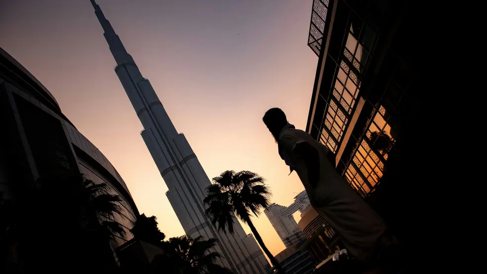 Osoba stojící poblíž Burj Khalifa během západu slunce v Dubaji, Spojené arabské emiráty