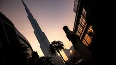 Osoba stojící poblíž Burj Khalifa během západu slunce v Dubaji, Spojené arabské emiráty