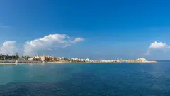 Klidná mořská hladina s výhledem na přístav a město