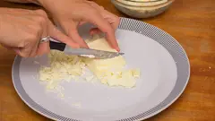 Různé druhy másla na dřevěném prkénku s nožem na mazání
