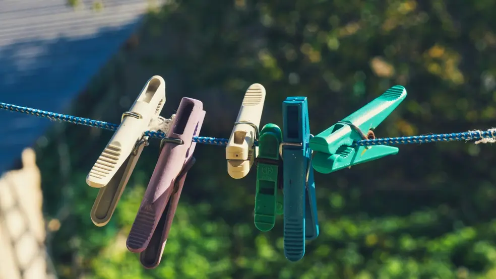 Kolíčky na prádlo zavěšené na šňůře ve dvoře během slunečného dne