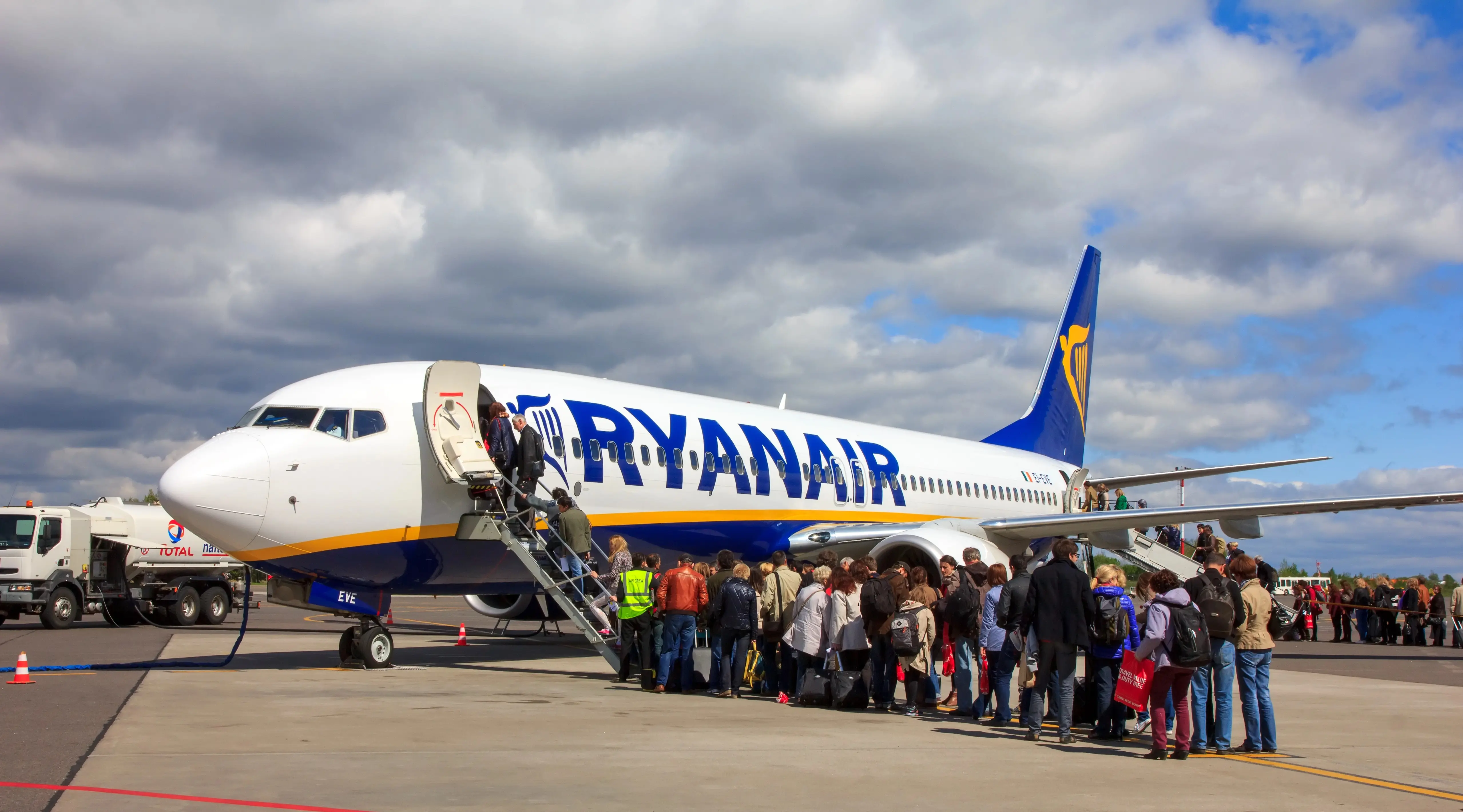 Dlouhá fronta cestujících před schůdky do letadla Ryanair zaparkovaného na letišti