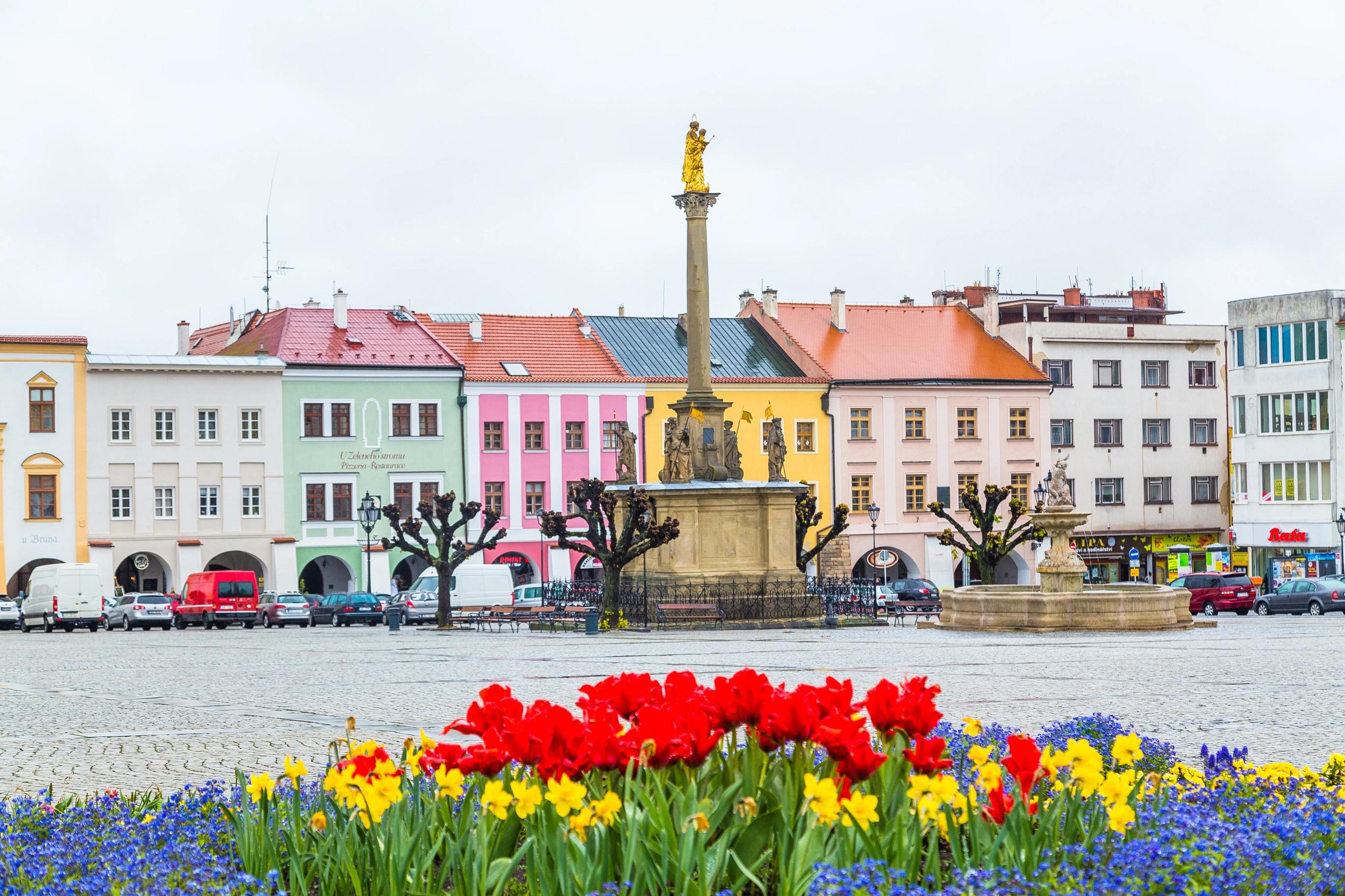 Barevné náměstí s kašnou a historickými domy,