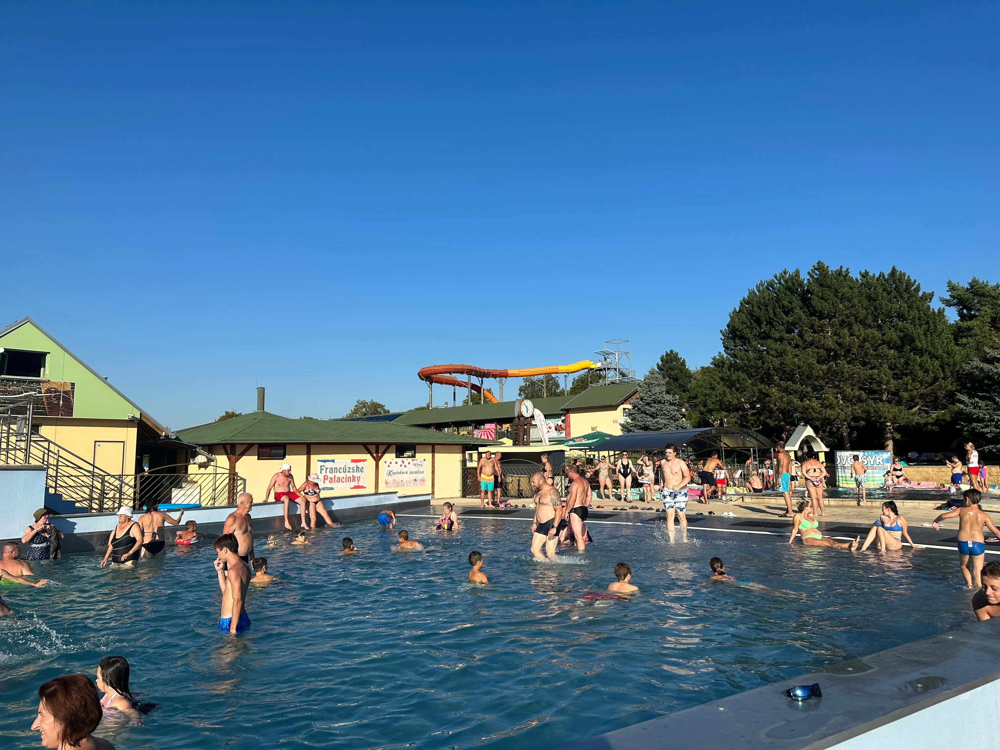 Lidé relaxují v termálním bazénu v Podhájske pod zataženou oblohou