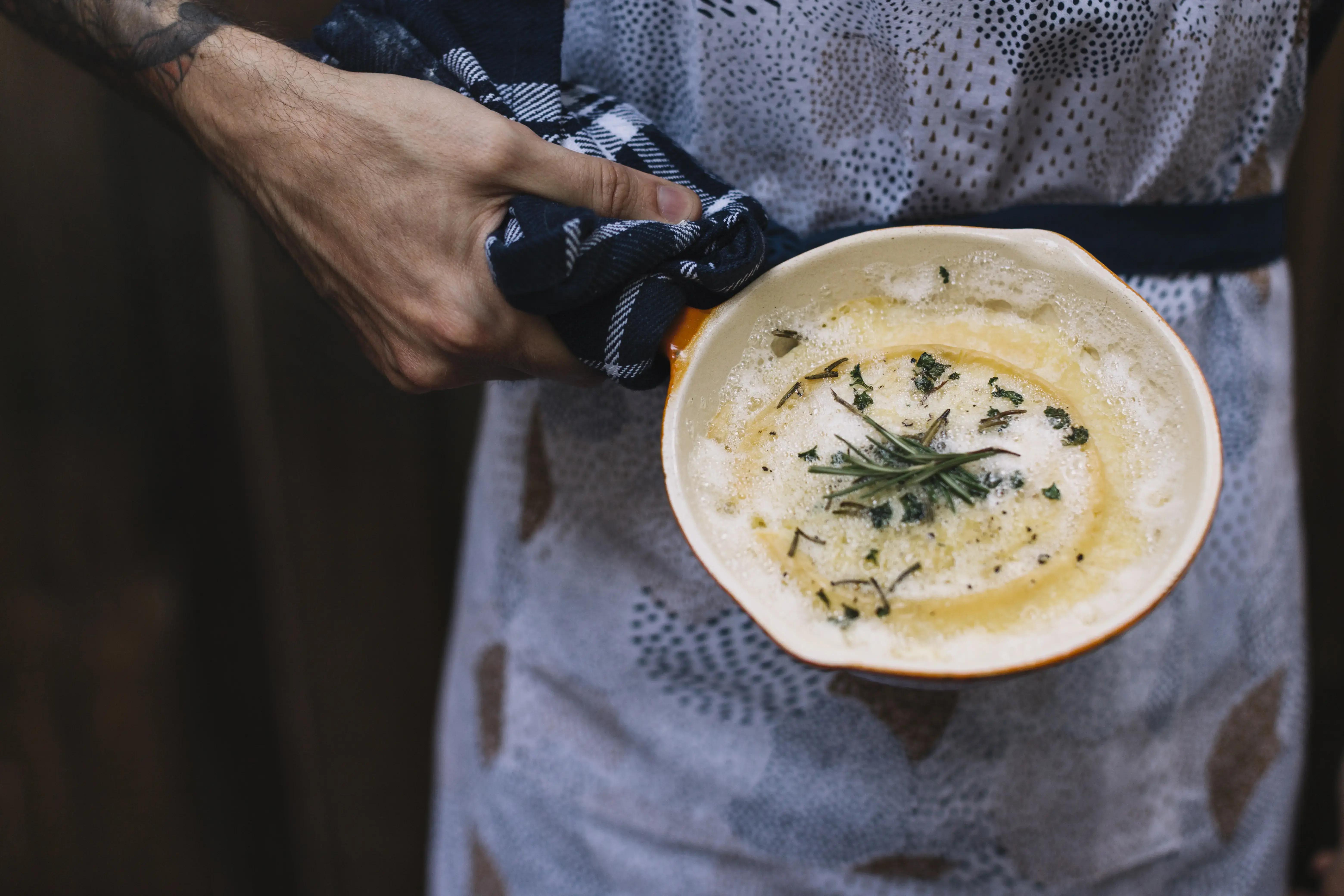 Hladká krémová omáčka v hrnci s dřevěnou vařečkou