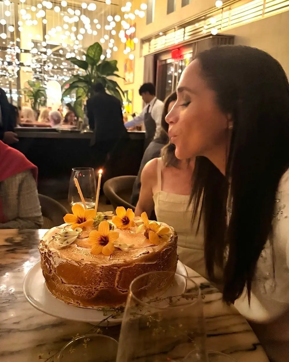 Meghan Markle sfoukává svíčky na dortu v restauraci