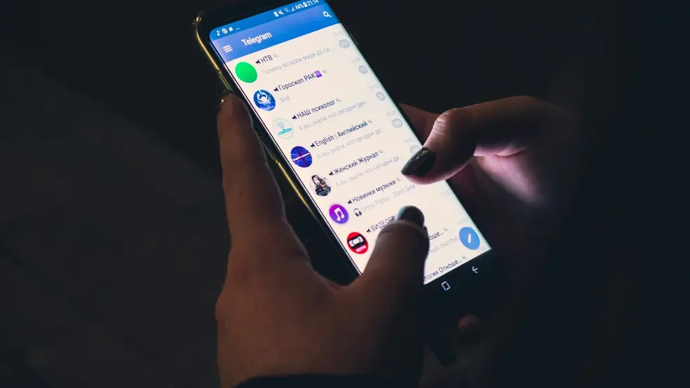 Uživatel prohlížející zprávy v aplikaci Telegram na smartphonu.