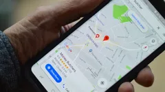 Mobilní telefon držený rukou s otevřenými Google Mapami, na kterých je vyznačena lokalizace.