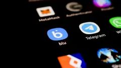 Detail domovské obrazovky mobilního telefonu s aplikacemi jako Telegram, Blu, a dalšími.
