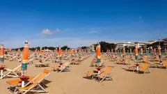 Prázdná pláž v Itálii s lehátky a barevnými slunečníky