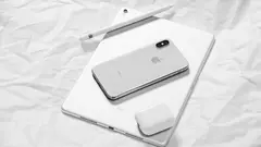 iPhone, iPad, AirPods a Apple Pencil na světlém pozadí.