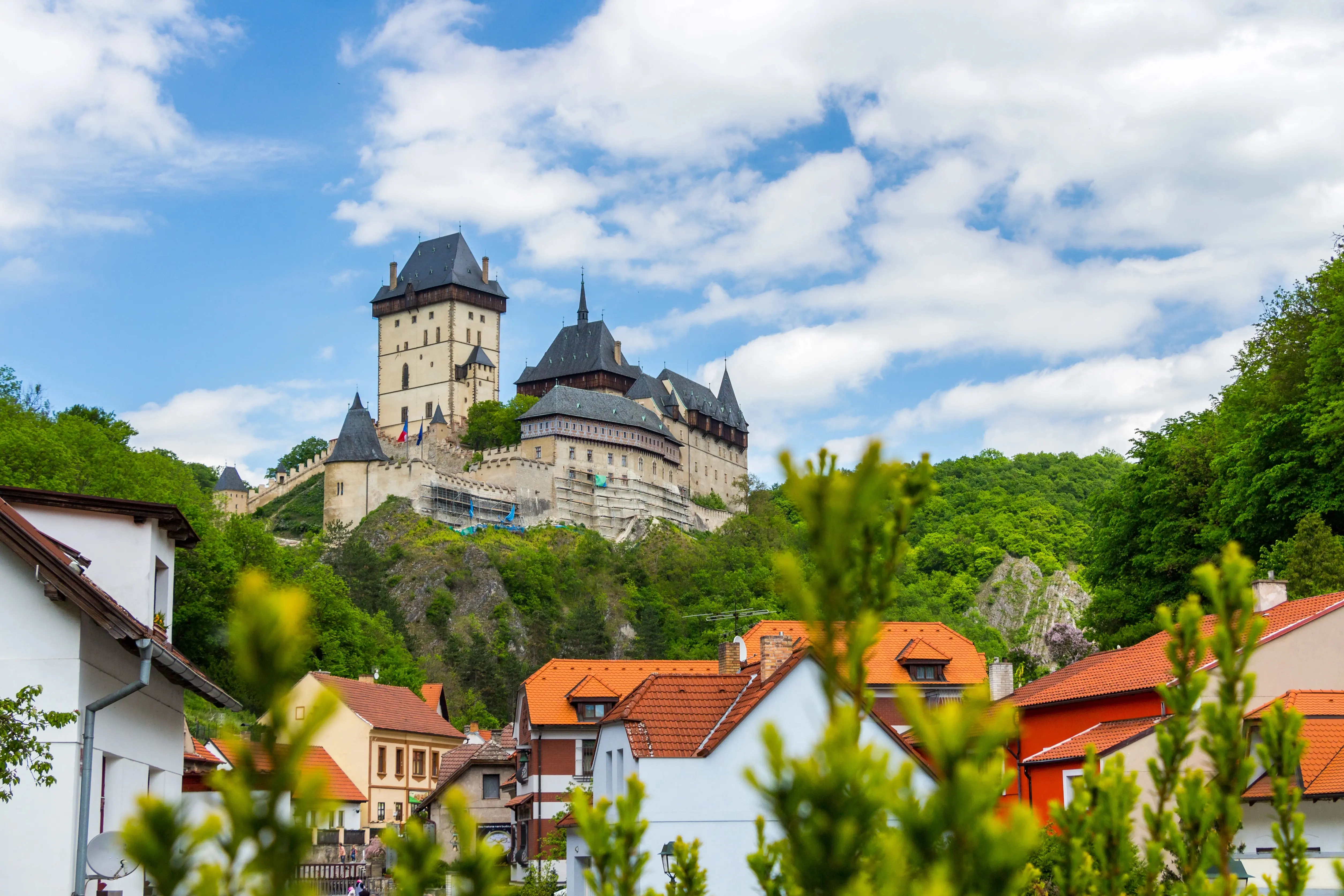 Karlštejn na kopci obklopený městem a zelení