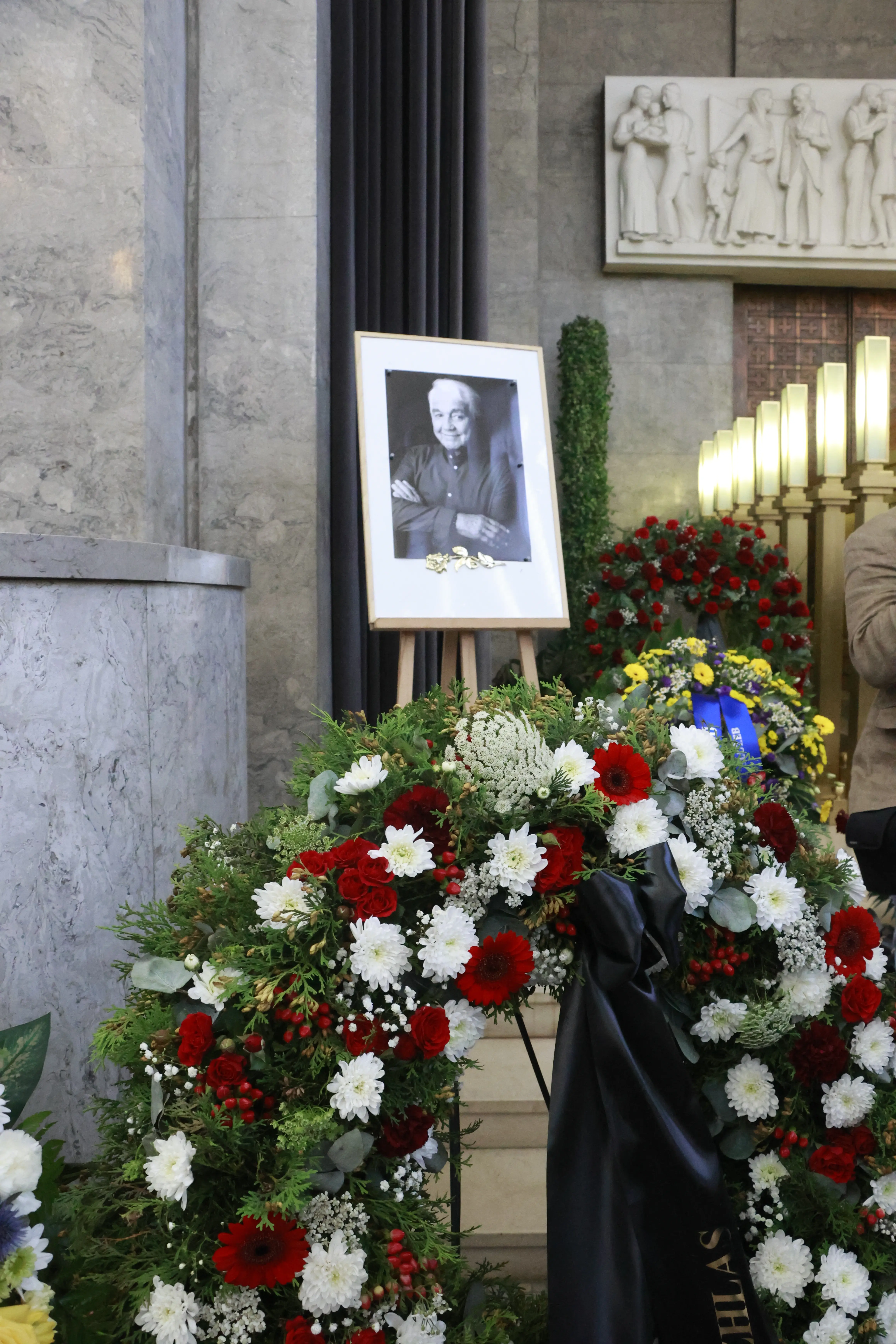Věnec z červených a bílých květů u portrétu Jiřího Krampola na jeho pohřbu