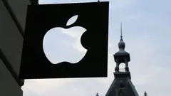 Černobílé logo společnosti Apple před budovou.