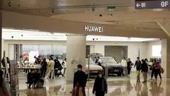 Pohled na Huawei obchod v nákupním centru s několika lidmi, kteří se procházejí kolem.