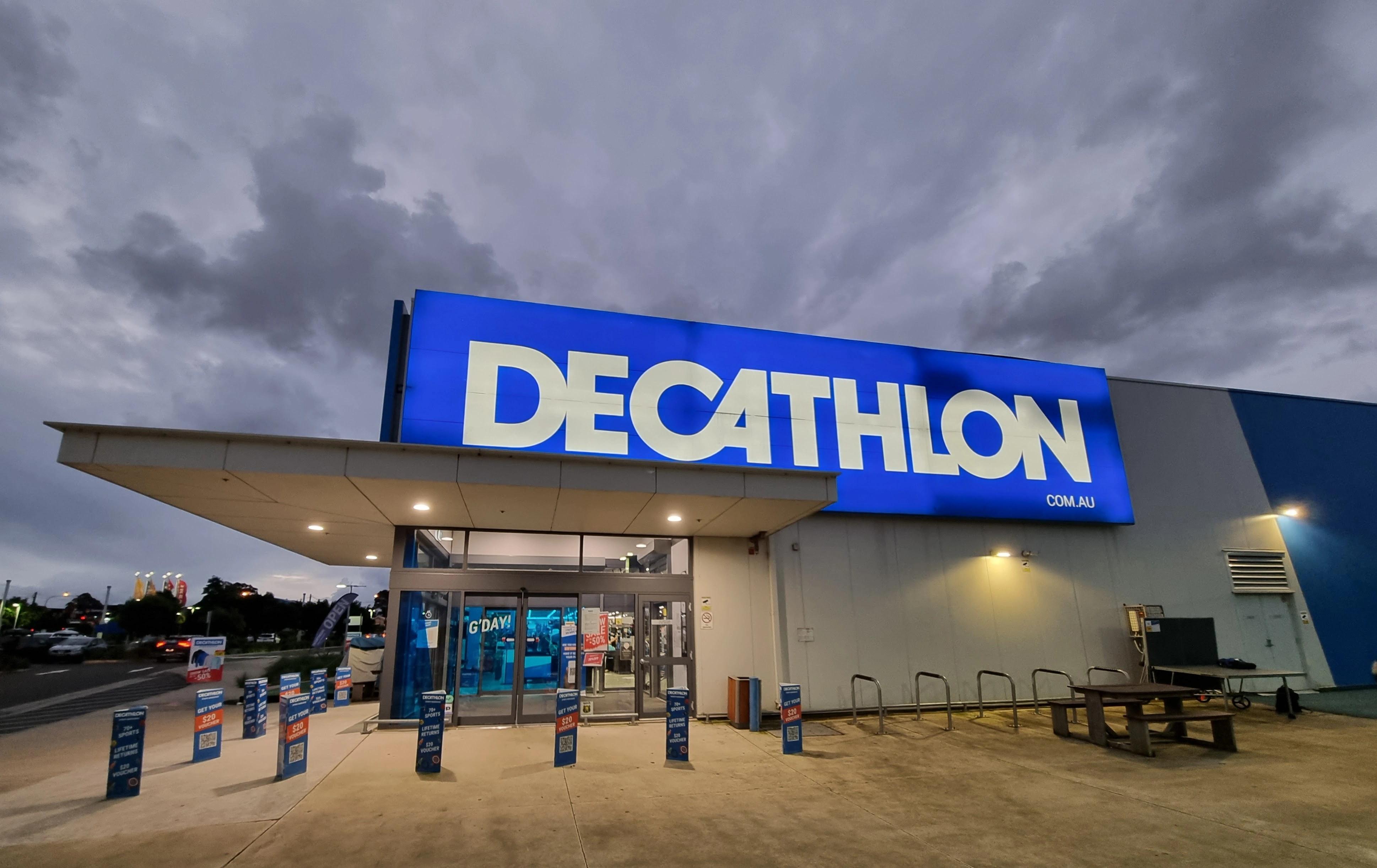 Pes na vodítku stojí před vchodem do prodejny Decathlon