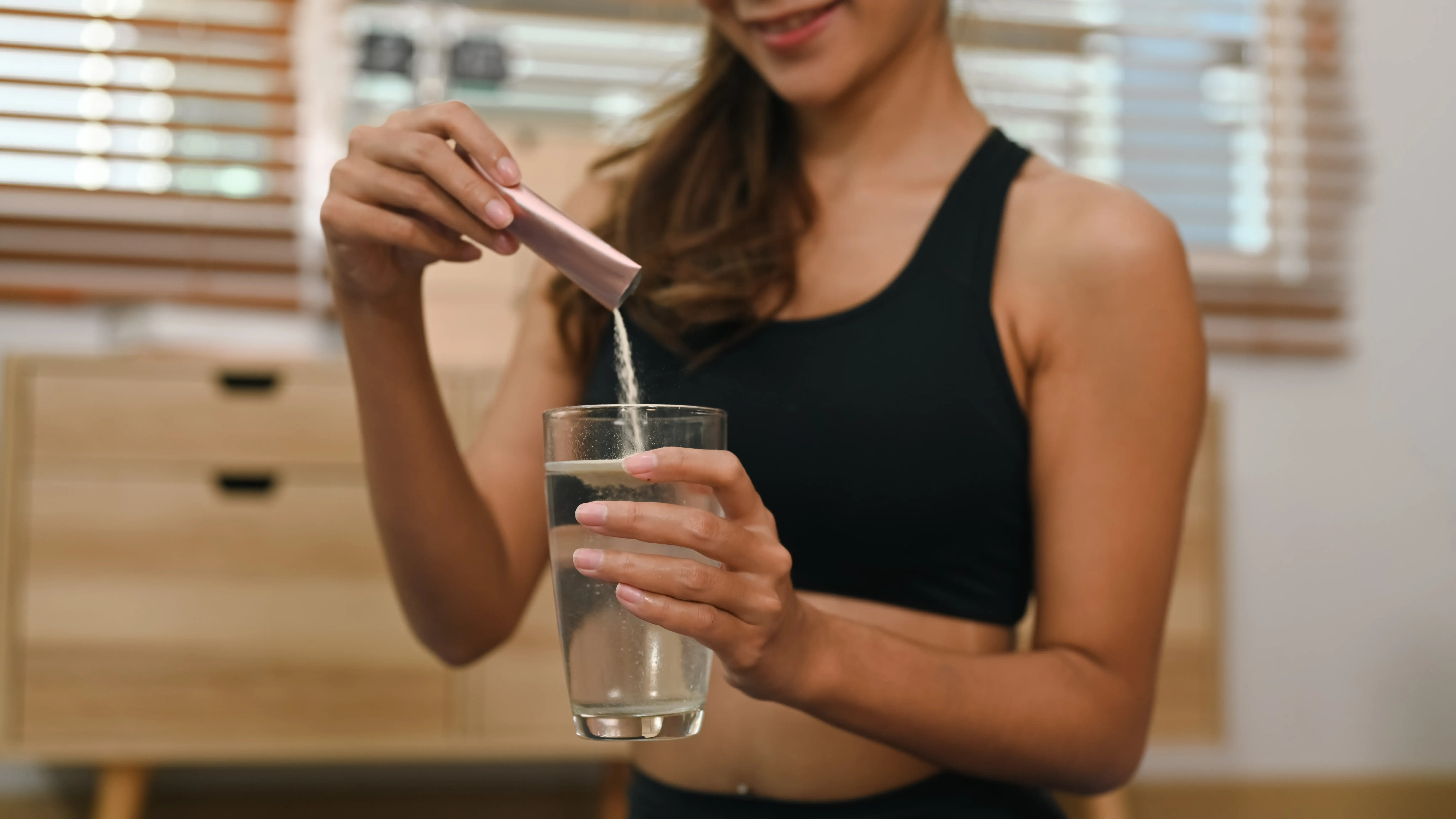 Žena doma připravuje proteinový nebo výživový nápoj
