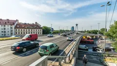 Pohled na dlouhý most přes řeku s modrou oblohou