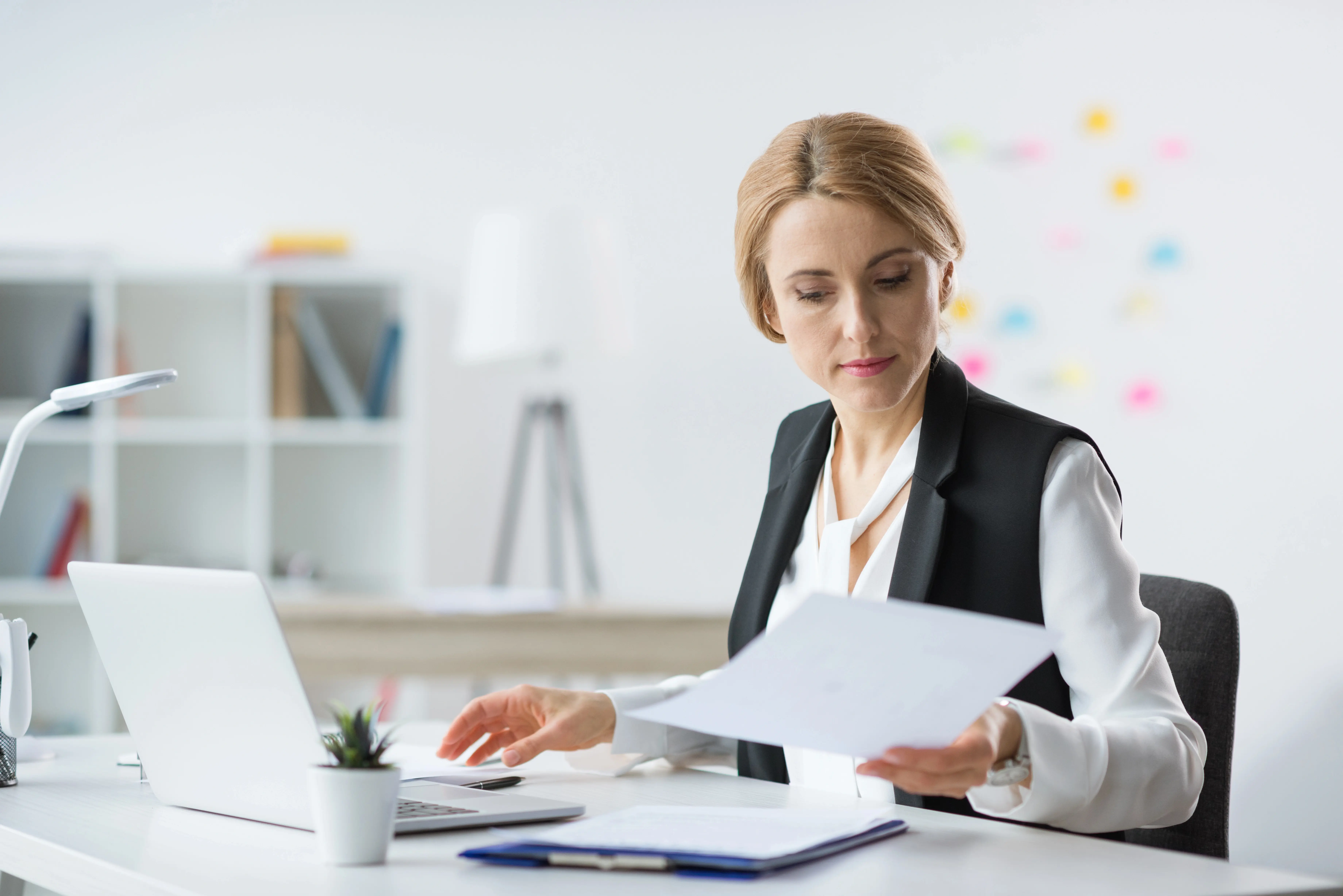 Mladá žena soustředěně pracuje u notebooku v moderním interiéru